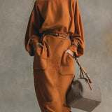 Narančasti top s okruglim izrezom i maxi suknja s džepovima od umjetne kože